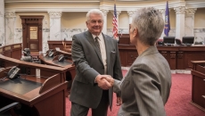 Politicians shaking hands in legislative chamber
