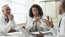 Doctors and informatics leaders speak at a table