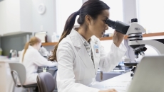 Lab worker using a microscope
