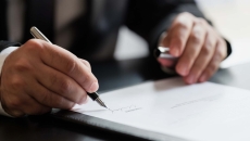 Businessperson signing piece of paper