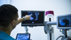 Healthcare worker pointing at x-ray image on monitor