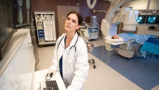 A doctor inspecting a patient's X-ray image on a monitor