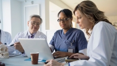 Doctors review information on a laptop
