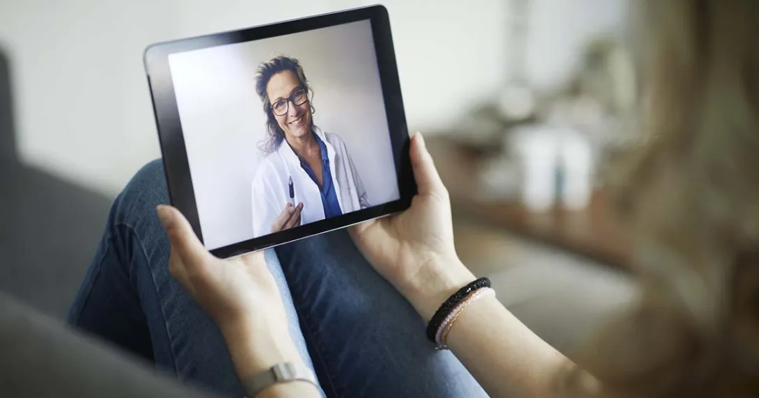 Female doctor on tablet for a telehealth visit