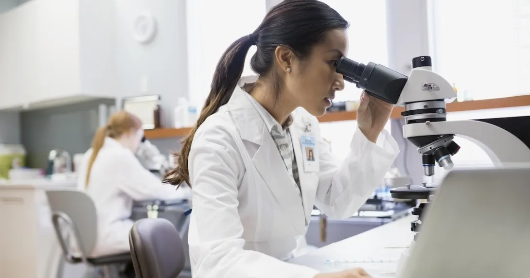 Lab worker using a microscope