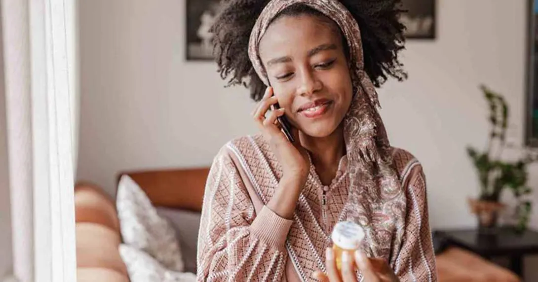 Person on the phone holding pill bottle