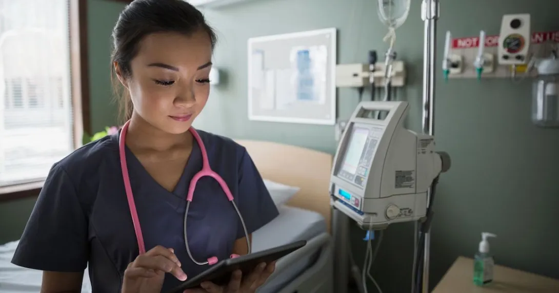 Nurse checks tablet to communicate on shift