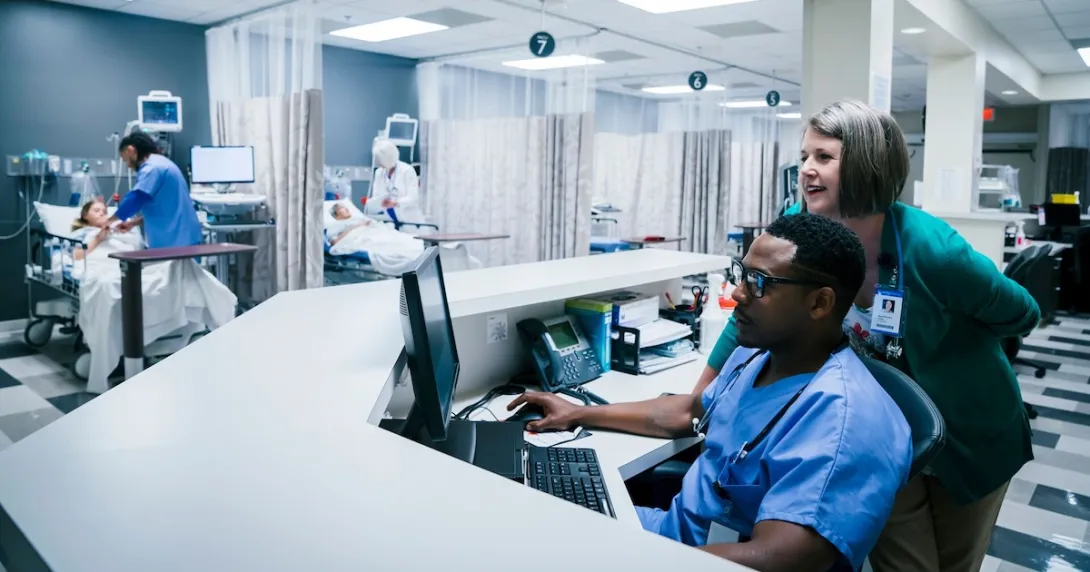 Nurses using a desktop computer in their station
